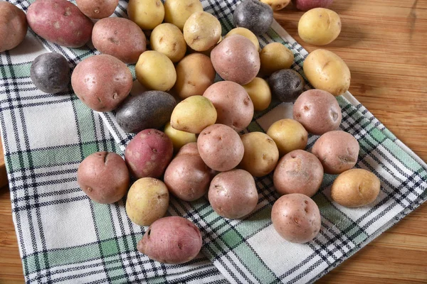 さまざまなキッチン タオルの上に小さなジャガイモ — ストック写真