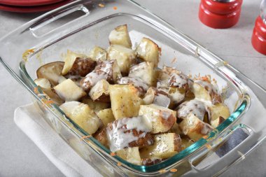 Bir güveç çanağı mozzarella ve jack peynir ile tepesinde cubed fırında patates