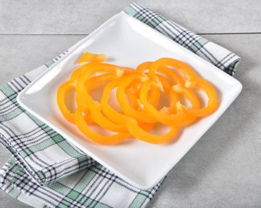 İnce dilimlenmiş turuncu biber bir plaka üzerinde