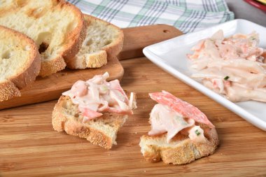 Yengeç ve karides kızarmış ciabatta ekmeği üzerinde gurme deniz ürünleri salatası.