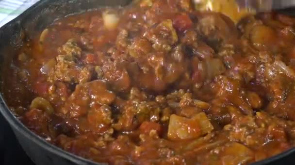 鋳鉄製の鍋に肉とパスタソースを攪拌のクローズ アップ — ストック動画