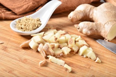 Bir kaşık dolusu yanında taze doğranmış organik zencefil kökü Toz zencefil