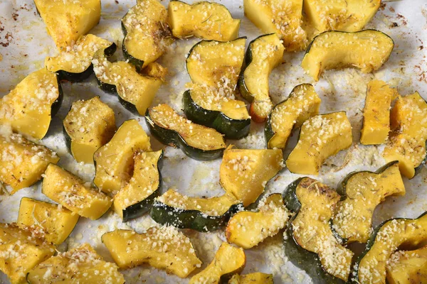 High angle view of acorn squash in a baking pan with parchment paper