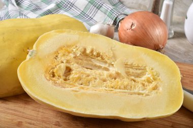 Dilimlenmiş spagetti squash tohumları ile kesme tahtası üzerinde hala içeride.