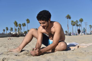 Yakışıklı genç adam sahilde bir sandcastle bina