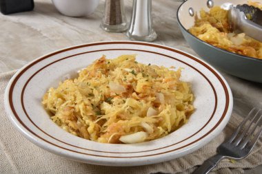 Bir kase sarımsak parmesan Spagetti Squash yanındaki bir tava