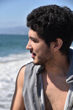 Okyanus üzerinde bir geminin güvertesinden arayan bir çok etnik gruptan oluşan yakışıklı genç.