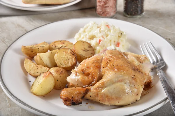A healthy chicken dinner with roasted baby potatoes and coleslaw