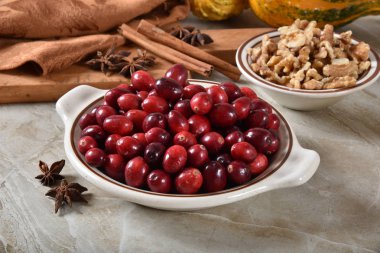 Bir kâse taze kızılcık kabuklu ceviz, Yıldız anason ve tarçın ile tatil yemek pişirmek için sopa