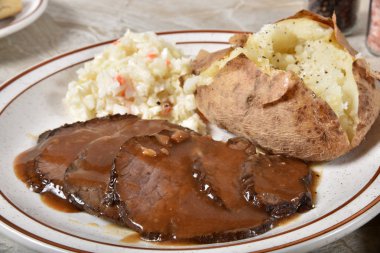 Dilimlenmiş biftek ve et suyu bir fırında patates ve salata ile gurme