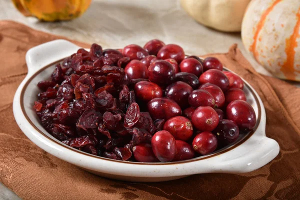 A bowl of fresh organic cranberries with dried cranberries