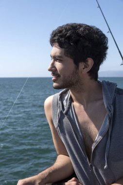 Bir tropik tatil bir balıkçı iskelesinden manzarayı bir koyu saçlı yakışıklı genç