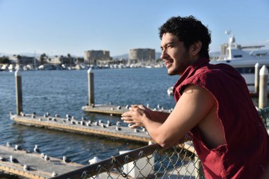 Mutlu genç çok etnik gruptan oluşan genç adam tatil tekne yat limanı bakan