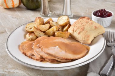 İçinde et suyu ile fırında patates dilimleri ve bir akşam yemeği rulo smothered dilimlenmiş hindi göğsü