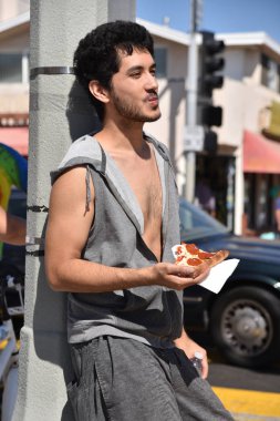 Bir dilim pizza bir iddialı beach şehirde altı karşı yaslanmış yemek koydu geri genç biri.