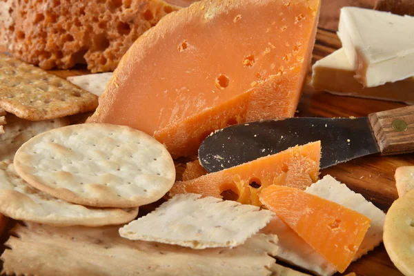 Wedges of gourmet Mimolette cheese with crackers and a cheese knife