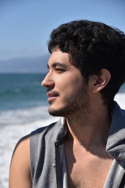 Okyanusa bakan bir iyi görünümlü koyu saçlı delikanlı