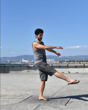 Mutlu bir genç adam bir tropikal tatil bir iskelede dans