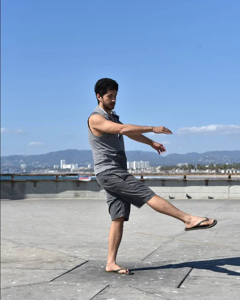 Mutlu bir genç adam bir tropikal tatil bir iskelede dans