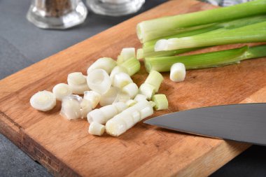 Bir kesme tahtası üzerinde taze organik yeşil soğan