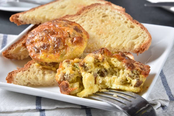 チーズとソーセージのバターを塗ったトーストの朝食を用意すると言ってたクラストなしの自家製オムライス カップ — ストック写真