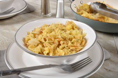 Bir kase gurme sarımsak parmesan spagetti Squash yanındaki bir dökme demir hizmet tava