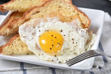 Sıcak, tereyağlı glutensiz ekmek üzerine kızarmış yumurta