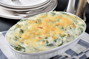 A serving dish of hot mashed potatoes with spinach and parmesan cheese clipart