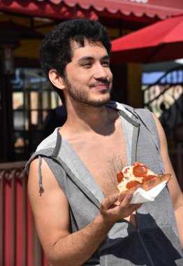 Yakışıklı mutlu genç adam yeme pizza açık havada