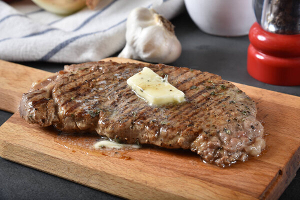 A juicy grilled rib steak with a pat of butter melting on top