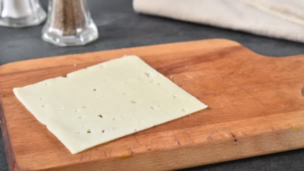 停止将瑞士奶酪切片堆叠在切割板上的运动动画 — 图库视频影像