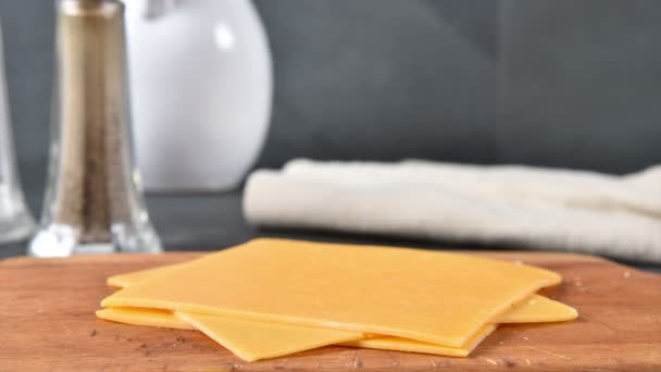 まな板にチェダーチーズのスライスを積み重ね 動きを止める — ストック動画