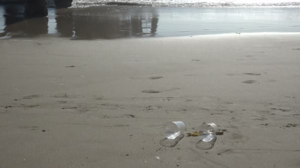 Выброшенные Пластиковые Чашки Пляже — стоковое видео