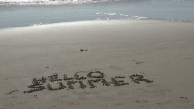 Güzel bir okyanus manzarasına kum tavada Merhaba Yaz kelimeleri