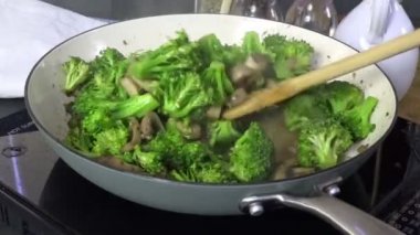 Bir tavada mantar ile sığır eti ve brokoli karıştırma