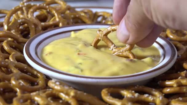 Een Gezouten Krakeling Dompelen Een Gerecht Van Kaas Saus — Stockvideo