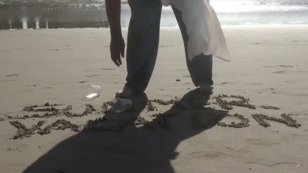 Homme Ramasse Des Tasses Plastique Sur Plage Par Les Mots — Video