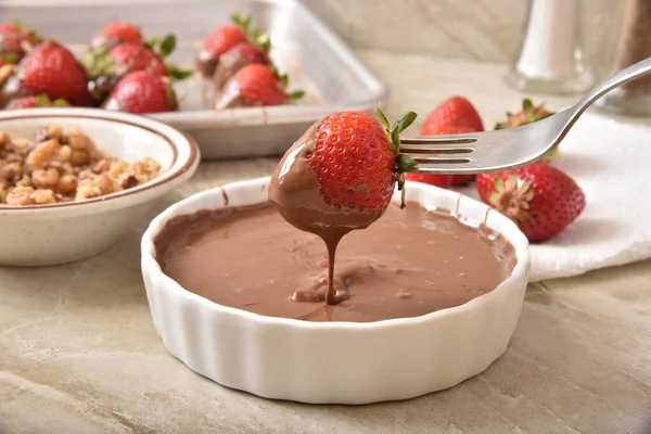 Dipping a strawberry in chocolate sauce — Stock Photo, Image