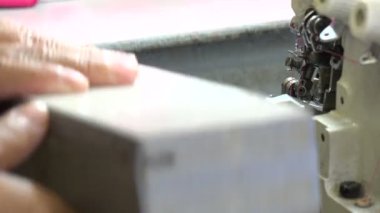 Profesyonel terzi, ticari dikiş makinesinde dikiş dikiyor.