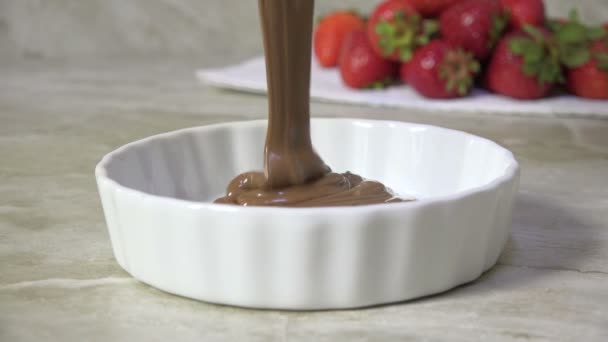 用新鲜草莓慢动作把融化的牛奶巧克力倒入一道菜中 — 图库视频影像