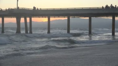 Kaliforniya 'daki Venice Beach İskelesi' nin hemen ötesindeki Santa Monica Dağları 'nın üzerinde gün batımı