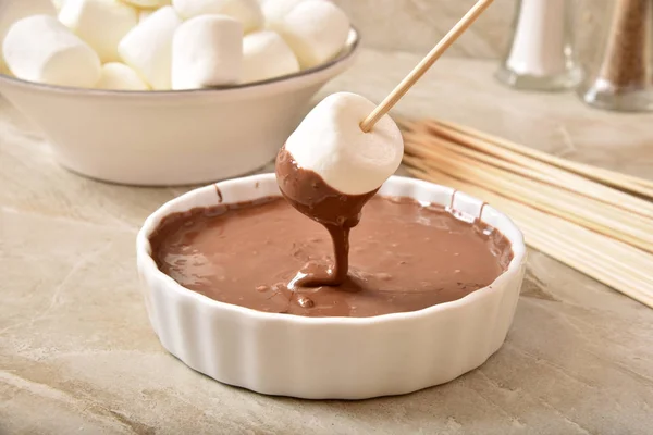 Dipping a marshmallow in chocolate — Stock Photo, Image