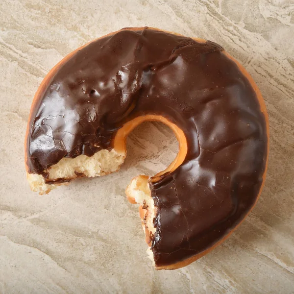 Chocolate donut with a missing bite