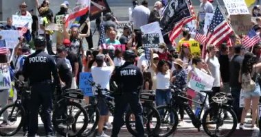 Los Angeles, CA / USA - 1 Mayıs 2020: Polis, COVID-19 karantinasını protesto etmek için belediye binasında yürüyen kalabalığa bariyer oluşturdu