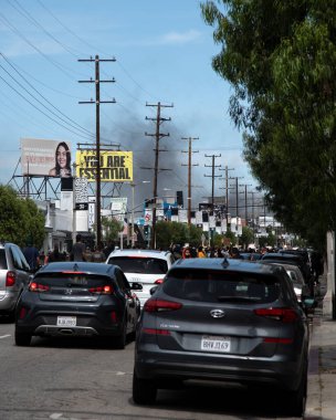 Los Angeles, CA / USA - 30 Mayıs 2020: Siyahi Yaşamı, 3. Cadde 'de George Floyd' un öldürülmesi üzerine protestocular, uzak mesafeden yanan polis arabalarından duman çıkıyor