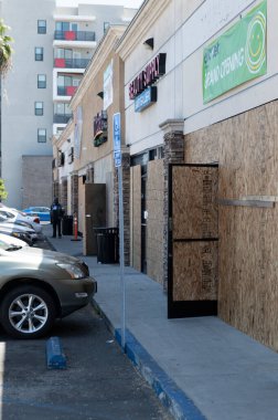 Long Beach, CA/USA -  June 6, 2020: A security guard watches over  a strip mall that was looted during the Black Lives Matter protests in Long Beach