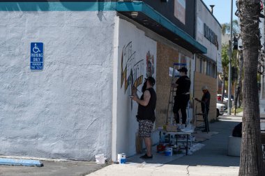 Long Beach, CA/USA - June 6, 2020: Artists painting over graffiti after the Black Lives Matter protests