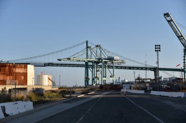 Los Angeles, CA / USA - 2 Mayıs 2020: Vincent Thomas Köprüsü Los Angeles Limanı 'ndaki petrol depolama tankları ve gantry vinçleri üzerinden uzanıyor