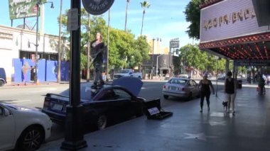 Hollywood, CA / USA - 20 Ocak 2020: Hollywood Bulvarı 'nda arabasının çatısında gitar çalan genç bir adam