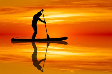 Günbatımında bir raket üzerinde duran adam